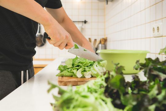 In der Küche wird frischer Salat aus dem Garten zubereitet –  eine bewusste und gesunde Ernährung ist wichtig für die Entwicklung eines ganzheitlichen Suchtverständnisses